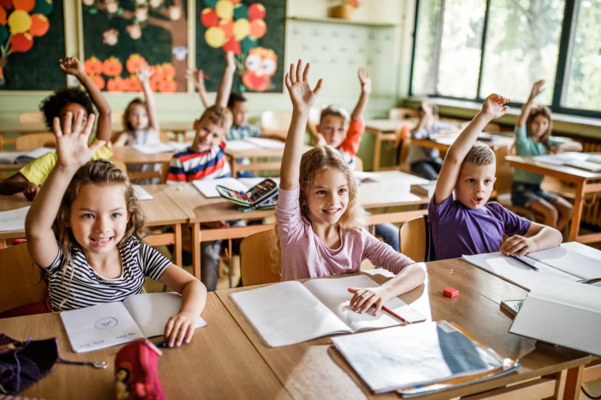 Begeisterte Grundschulkinder melden sich im Unterricht